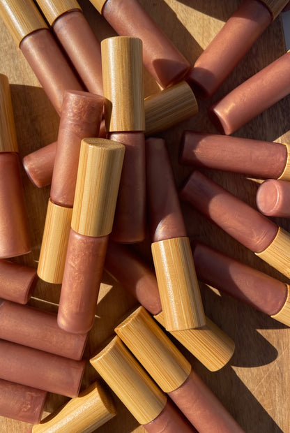 CastorSpell Strawberry Kisses natural castor oil lip gloss glass tube, unlabelled to show natural colour